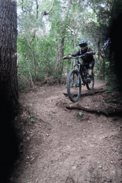 Person Riding Bike Down Dirt Trail