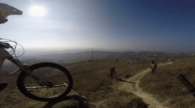 Person Riding Bike on Dirt Path With Giant Tire