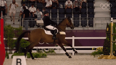 Person Riding Brown Horse In Front Of Sign Saying B GIF