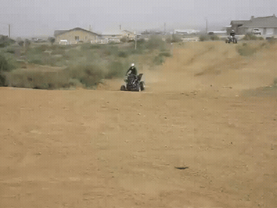 Person Riding Dirt Bike On Dirt Road With House GIF