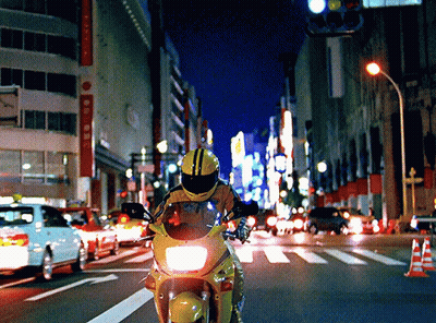 Person Riding Motorcycle Down Street At Night GIF