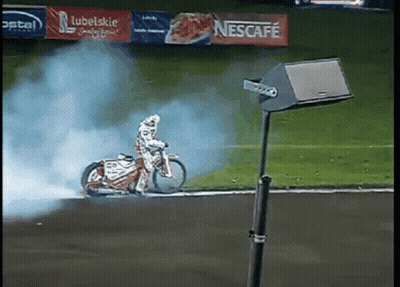Person Riding Motorcycle on Track With Nescafe Banner