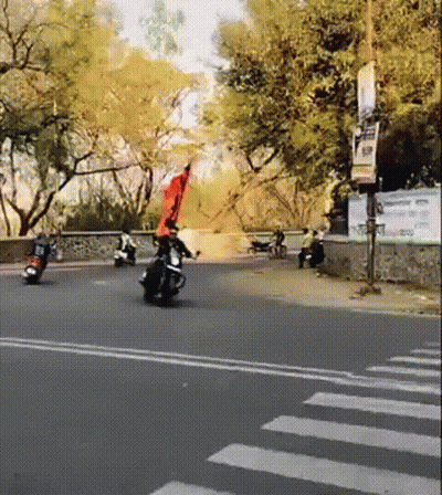 Person Riding Motorcycle With Red Flag GIF