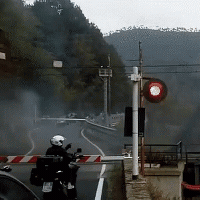 Person Riding Motorcycle With Red Light Behind GIF