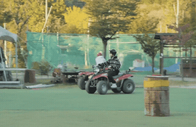 Person Riding Red And Black ATV On Green Field GIF