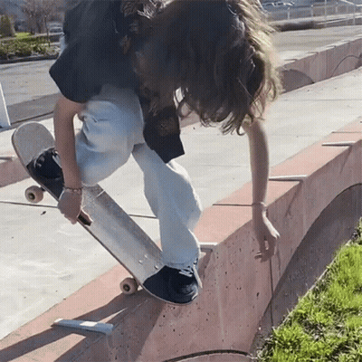 Person Riding Skateboard on Concrete Ramp