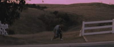 Person Running In Field With Fence GIF