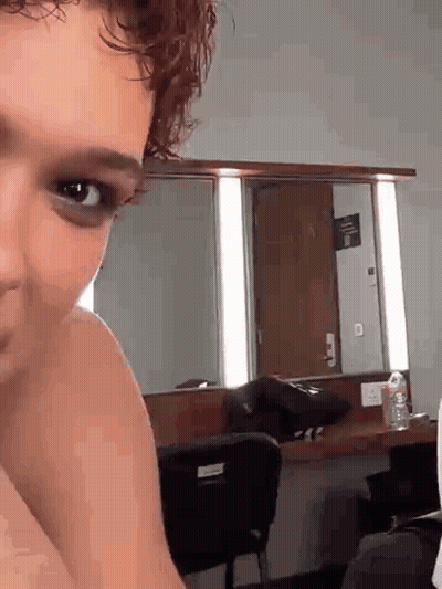 Person's Face In Dressing Room Mirror GIF