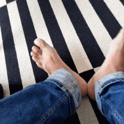 Person's Feet On Black And White Rug GIF