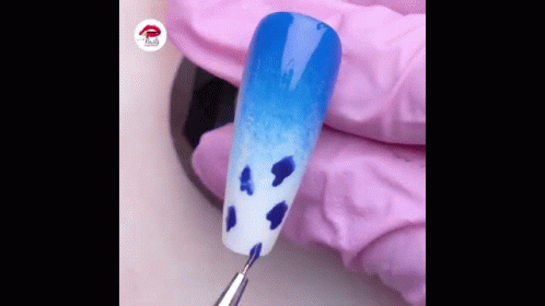 Person's Hand Holding Nail With Blue And White Design GIF