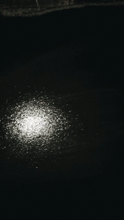 Person's Hand On Black Surface With White Dots GIF