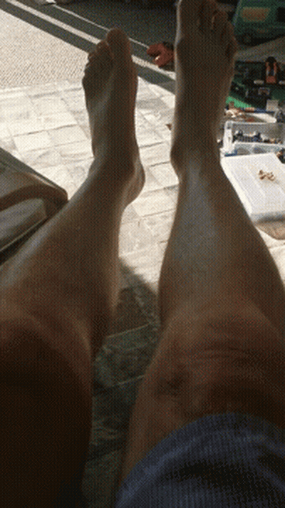 Person's Legs Laying On Tiled Floor GIF