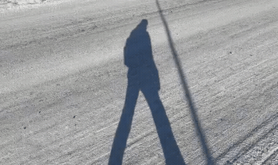 Person's Shadow On Snowy Road GIF