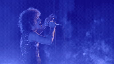 Person Singing Into Microphone With Star Shirt GIF