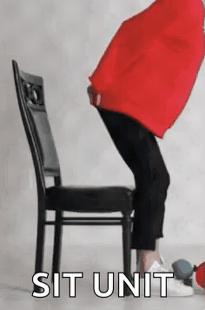Person Sitting Cross-Legged On Chair With Red Pillow GIF