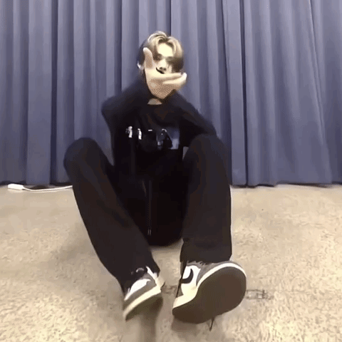 Person Sitting Crossed Legs Making Peace Sign GIF