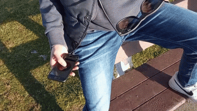 Person Sitting On Bench Holding Phone And Sunglasses GIF