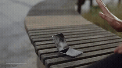 Person Sitting On Wooden Bench With Cell Phone GIF