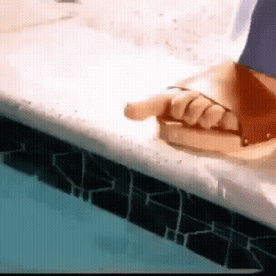 Person Sitting Pool Edge Pointing At Book GIF