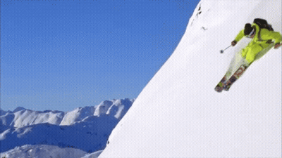 Person Skiing Down Snowy Mountain GIF