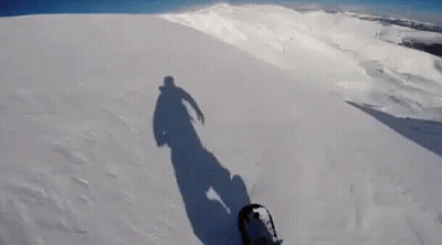 Person Snowboarding Down Snowy Hill GIF