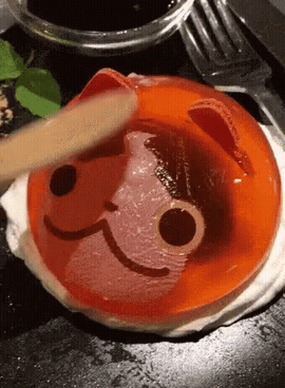 Person Spreading Cat Face Jelly With Wooden Spoon GIF