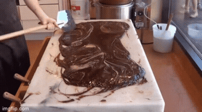 Person Spreading Chocolate On Cutting Board GIF