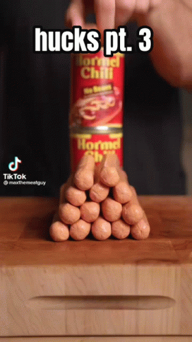 Person Stacking Hot Dogs On Horned Chili Can GIF