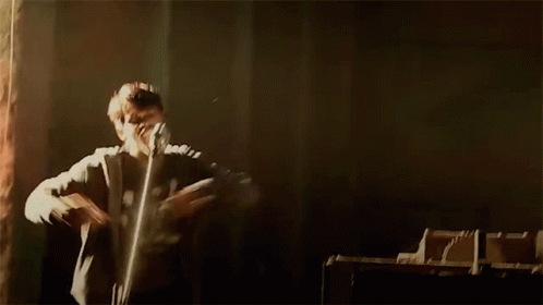 Person Standing Arms Outstretched In Dark Room GIF