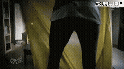 Person Standing Before Yellow Curtain GIF