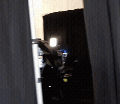 Person Standing In Dark Room With Light GIF
