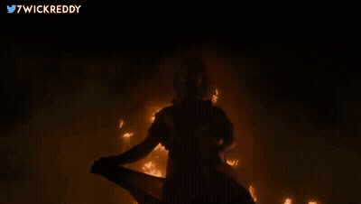 Person Standing In Front Of Fire With Twitter Username 7Wickreddy GIF