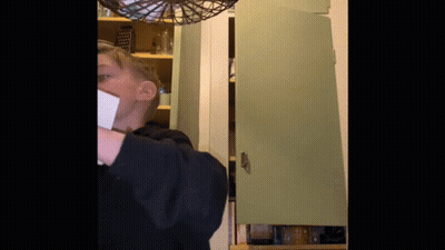 Person Standing In Front Of Green Cabinet GIF