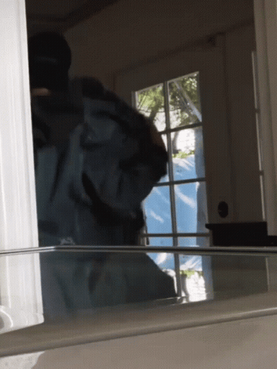 Person Standing In Front Of Window With Blue Tarp GIF