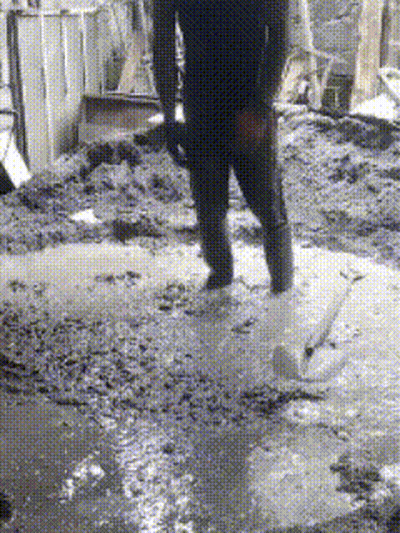 Person Standing In Muddy Puddle Holding Shovel GIF