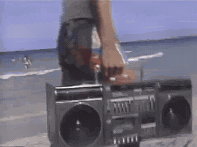 Person Standing Next To Boombox On Beach GIF
