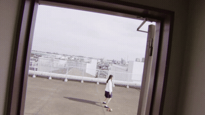 Person Standing On Rooftop With City View GIF