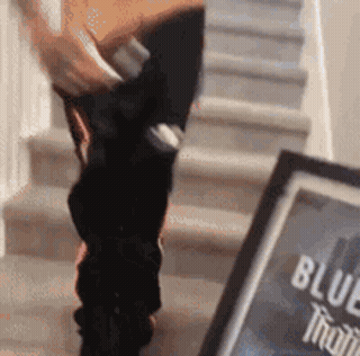 Person Standing On Stairs Next To Blue Bottle GIF