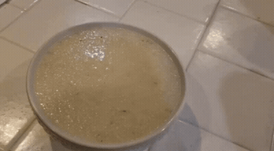 Person Stirring Bowl Of Food With Spoon GIF