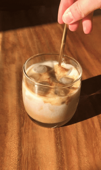 Person Stirring Iced Coffee With Spoon GIF