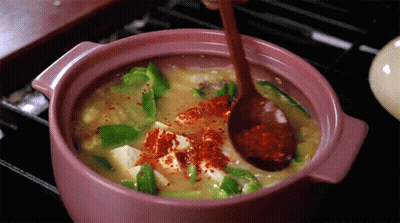 Person Stirring Pot Of Food With Spoon GIF