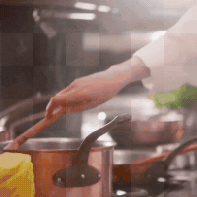 Person Stirring Pot Of Food With Wooden Spoon GIF