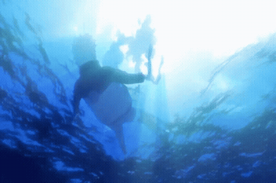 Person Swimming In Ocean With Sun Shining Through GIF