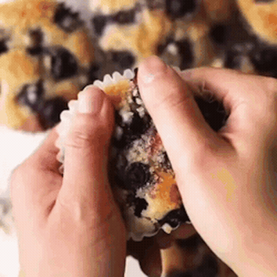 Person Taking A Bite Of Blueberry Muffin GIF
