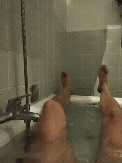 Person Taking Bath With Feet In Water GIF
