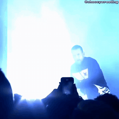 Person Taking Photo Of Man In Blue Wrestling Shirt GIF