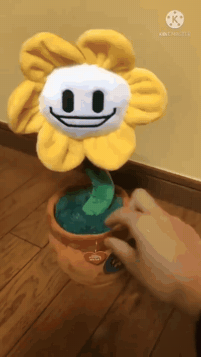 Person Touching Stuffed Flower In Pot GIF