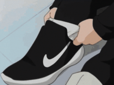 Person Tying Shoe With White Nike Logo GIF