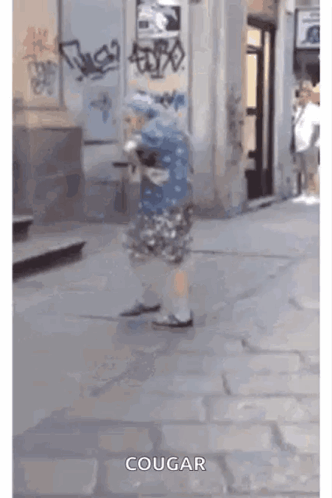 Person Walking Down Sidewalk With Word Cougar GIF