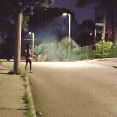 Person Walking Down Street At Night With Emerson Sign GIF